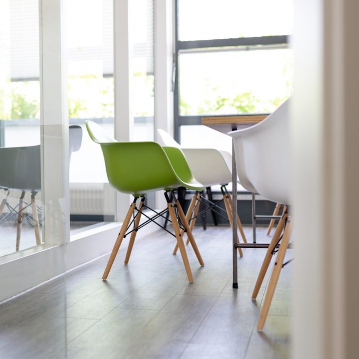 Personalberater jorbis jorbis Teamkollegin mit Tablet und Kaffeetasse lächelt an einem Tisch im Büro.