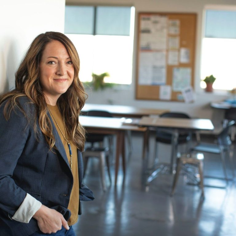 Personalberater jorbis Eine lächelnde Frau im jorbis Team in einem Raum mit Tischen und Stühlen.